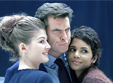 Pierce Brosnan clowns with Rosamund Like and Halle Berry at the press conference at the start of shooting on Die Another Day (2002)