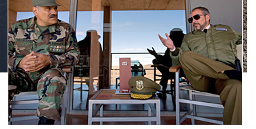 General Medrano (Joaquin Cosio) and the Chief of Police (Fernando Guillen-Cuervo) await Greene's arrival at Perla Las Dunas, Bolivia