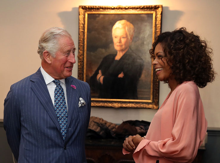 Prince Charles and Naomie Harris in front of a portrait of Judi Dench as M
