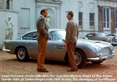 Sean Connery and Guy Hamilton chat in front of the Aston Martin DB5 at Stoke Poges Golf Club
