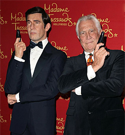 George Lazenby poses with his wax figure during Madame Tussauds Hollywood reveal of all six James Bonds as the temporary exhibit opens in the US.